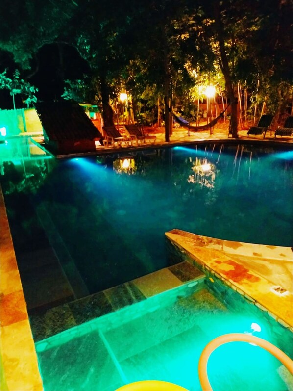 Una piscina cubierta, una piscina al aire libre, tumbonas