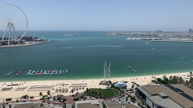 A coastal cityscape with a large Ferris wheel, a beach, and a marina. - Pelicanstay Seaview Suites in JBR Walk (Dubai)