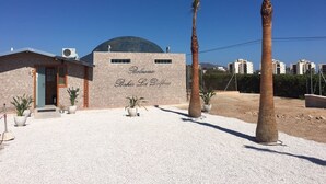 Un edificio con un letrero que dice "Balneario Bahia Los Delfines" y una estructura en forma de cúpula en el techo.