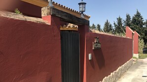 A red building with a black door, a small sign above the door, and a lamp on the roof.
