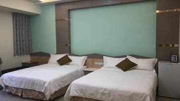A hotel room with two beds, a large window, and a flat-screen TV.