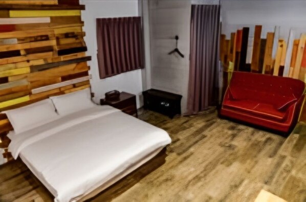 A bedroom with a bed, a red sofa, a wooden headboard, a wardrobe, and a hanging coat rack. - l-stack B&B (Magong)