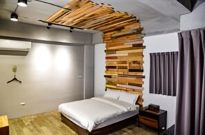 A bedroom with a bed, a wooden headboard, a nightstand, a hanging plant, and a window with curtains. - l-stack B&B (Magong)