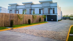 A modern building with a flat roof, stone facade, and a paved driveway. - Sky Hotel Pampanga (Bacolor)