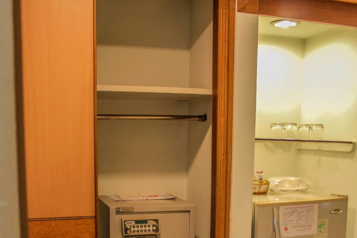 Uma kitchenette compacta com geladeira, um freezer pequeno e micro-ondas embutido.