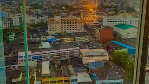 A cityscape view from a high-rise window during sunset. - Yannaty Hotel Halal (Hat Yai)