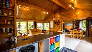 Interior de una cabaña de madera con cocina, comedor y sala de estar.