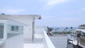 A modern building with a glass balcony overlooking a beach. - Heyyo Hostel (Hualien City)