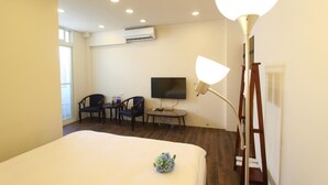A hotel room with a bed, a desk with two chairs, a TV, and a lamp. - Heyyo Hostel (Hualien City)
