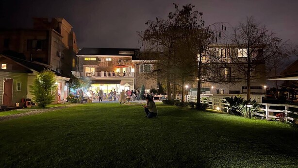 Un patio con un edificio que tiene varios balcones y una entrada bien iluminada.