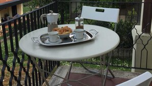 A balcony with a round table set for breakfast, including croissants and coffee. - Cris&Giuli House (Barberino Tavarnelle)