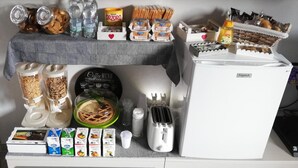 A kitchenette with a coffee maker, toaster, and various food items including bread, snacks, and condiments. - Cris&Giuli House (Barberino Tavarnelle)
