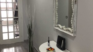 A hallway with a white console table, a mirror with a distressed frame, and a door leading to a room with a window. - Cris&Giuli House (Barberino Tavarnelle)