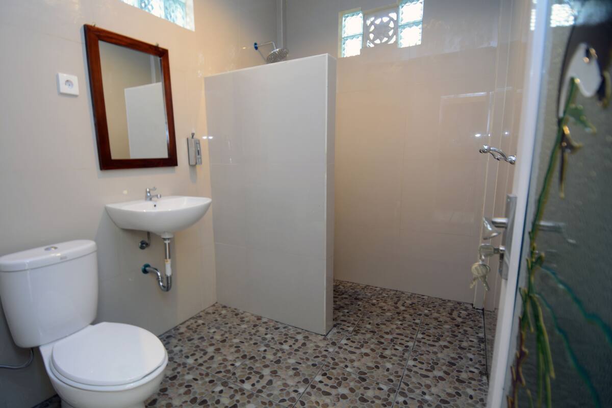 A bathroom with a toilet, sink, and shower.