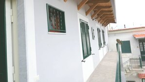 A corridor with white walls, green shutters, and a wooden ceiling. - Nolana 86 (Pompei)