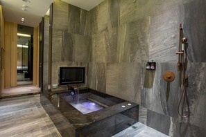 A modern bathroom with a large bathtub, a built-in TV, and a shower system. - Birdman Motel (Taichung)