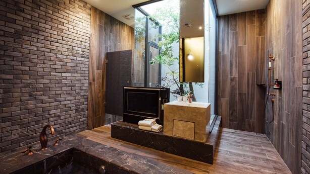 A modern bathroom with a large bathtub, a vanity with a mirror, and a shower area.