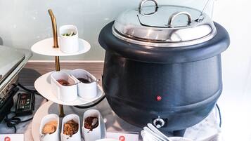 Una cocina equipada con una olla grande, varios platos para servir y utensilios.