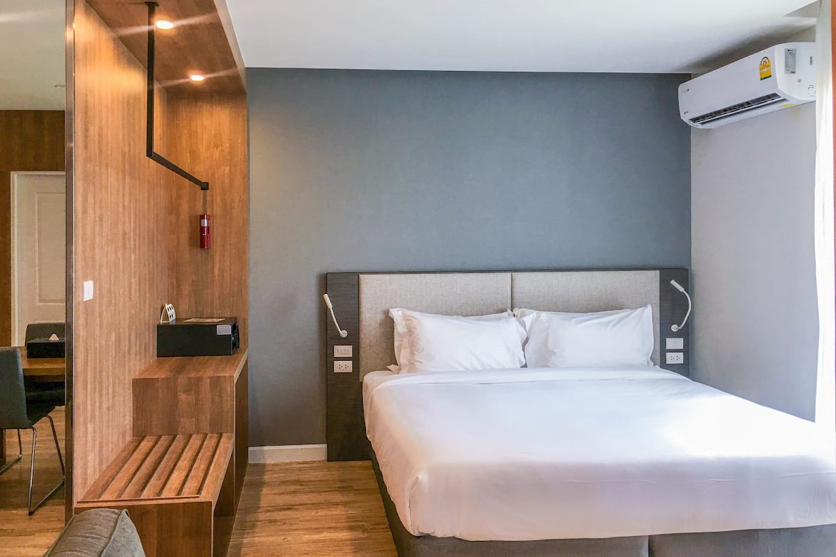 Una habitación de hotel moderna con una cama grande, un escritorio y una silla.