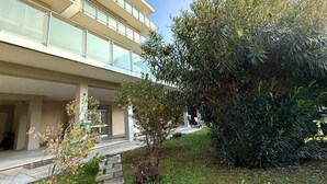 Un edifici modern amb diverses plantes, una passera coberta i vegetació abundant.