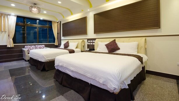 A hotel room with two beds, a large window, and a chandelier. - Xianfeng B&B (Hualien City)