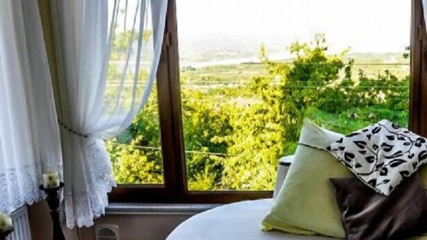 Ein Zimmer mit großem Fenster, einer gepolsterten Bank und einer Heizung.