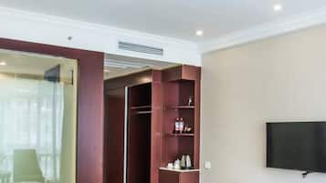 A hotel room with a bed, a wardrobe, a desk, and a television.