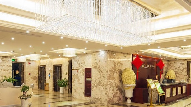 A spacious lobby with a high ceiling, marble flooring, and a reception area with a red sign. - Aode Hotel (Hangzhou)