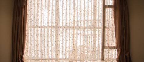 A window with sheer curtains and a view of the outside.