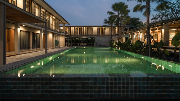 A modern hotel with a swimming pool, multiple balconies, and tropical landscaping. - SUNKISS pool.bed.cafe (Bangkok)