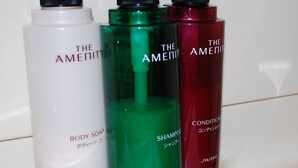 Tres botellas de jabón, champú y acondicionador de la marca The Amenity.