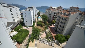 A residential area with a swimming pool, multiple balconies, and a view of the sea. - Almena City Hotel (Marmaris)