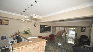A spacious lobby with a reception desk, seating area, and a staircase leading to upper floors. - Almena City Hotel (Marmaris)