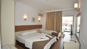 A hotel room with two beds, a desk, and a window with curtains. - Almena City Hotel (Marmaris)
