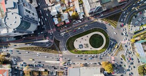 Vista aérea de una glorieta con múltiples accesos y salidas, rodeada de edificios y carreteras.
