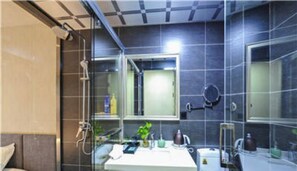 Ein modernes Badezimmer mit Duschkabine aus Glas, einem weißen Waschbecken und einem Spiegel.