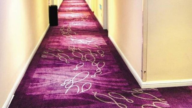 A hotel hallway with a purple carpet, recessed lighting, and an exit sign. - Heng 8 Hotel Hangzhou Xiaoshan Airport (Hangzhou)
