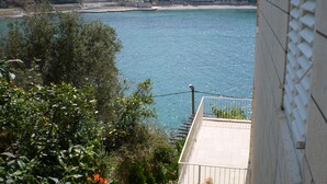 A coastal view with buildings and a clear blue sea. - Karla Apartments (Dubrovnik)