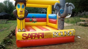 An inflatable safari bounce with animal faces and the words "SAFARI BOUNCE" on it. - Kajiado Cultural Resort (Bisil)