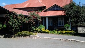 A building with a red roof and a covered porch. - Kajiado Cultural Resort (Bisil)