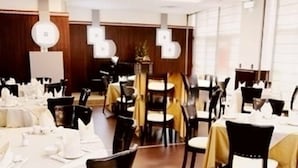A dining area with tables set for service, wooden paneling on the walls, and pendant lighting. - Zhongdun Boutique Hotel (Hangzhou)