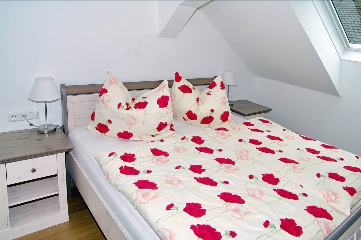 Ein Schlafzimmer mit einem Bett, zwei Nachttischen und einem Beistelltisch.