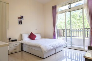 A bedroom with a bed, a nightstand, a window with curtains, and a view of greenery outside. - Fully B&B (Puli)