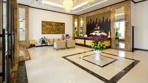 A modern lobby with a reception desk, seating area, and decorative elements. - Golden Line Danang Hotel (Da Nang)