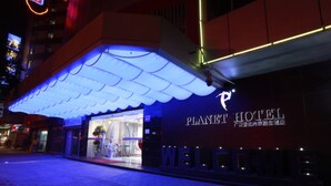Exterior do Hotel Planet, com toldo iluminado e placa de boas-vindas.