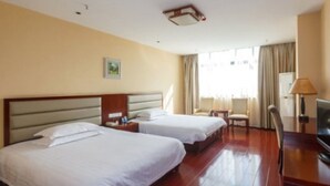 Habitación de hotel con dos camas, televisión, escritorio y una silla.
