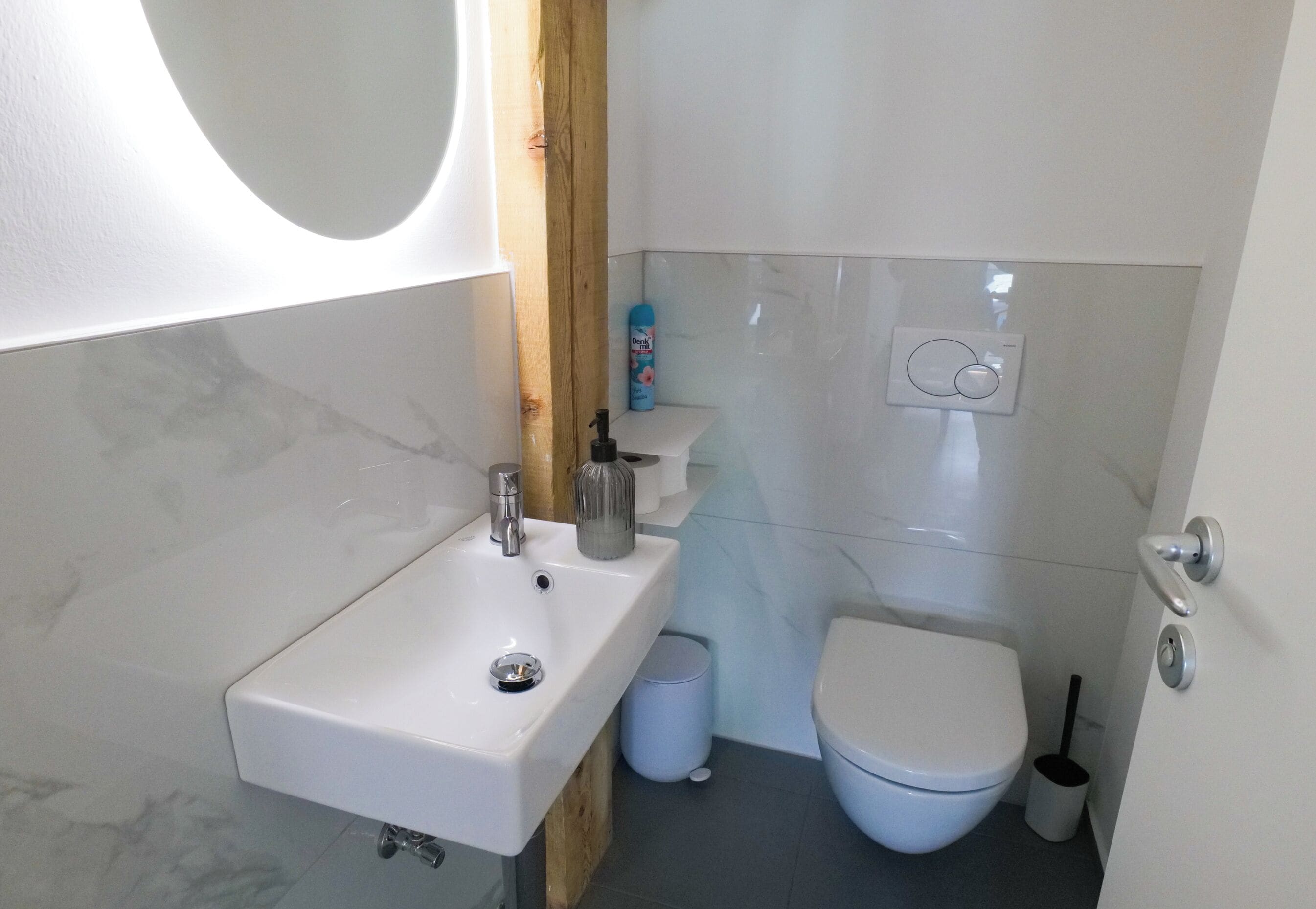 A compact bathroom with a white sink, a toilet, and a bidet.