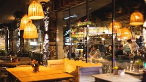 An indoor dining area with tables and chairs, hanging lamps, and a view of the bar area. - MOUNTAIN LUIS - HOTEL | SUITES | PENTHOUSES (Kaprun)