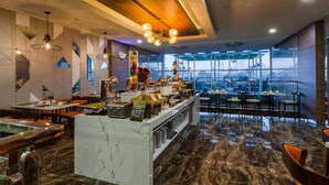 Un restaurante moderno con mostrador de mármol, zona de estar y amplios ventanales con vistas a la ciudad.