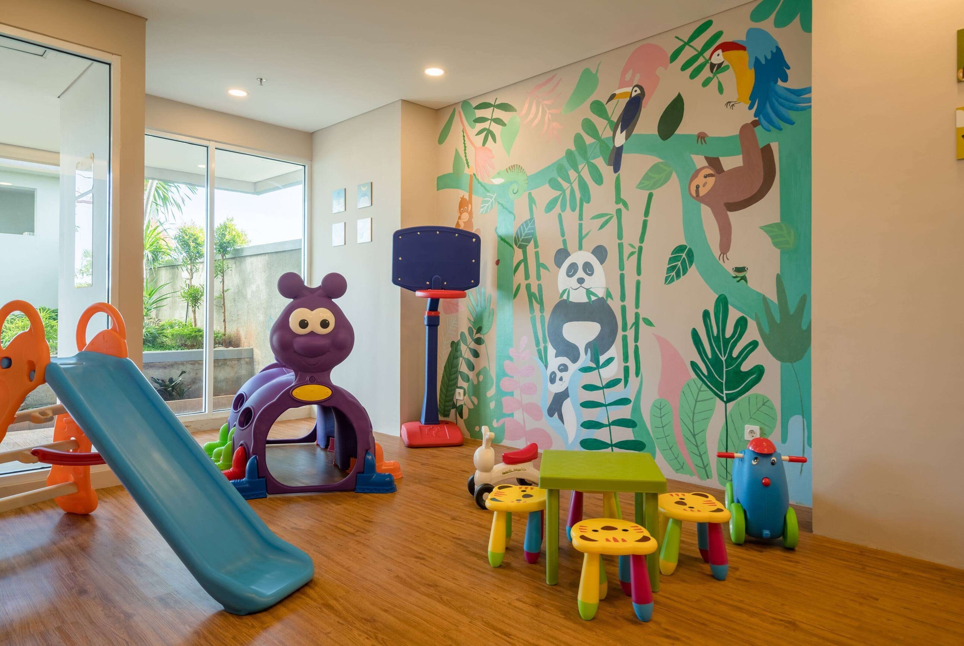 A children's play area with a slide, climbing structures, and colorful stools.